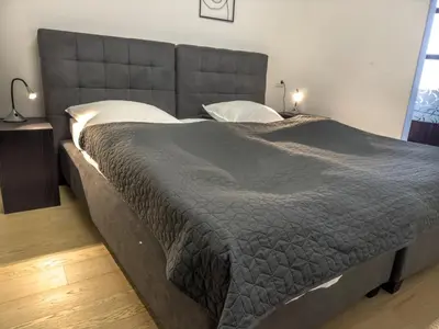 a large bed in a bedroom with two pillows at Eiprova by the river in Ljubljana