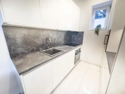 a kitchen with white cabinets and a sink at Eiprova by the river in Ljubljana