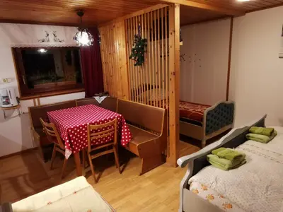 a dining room with a table and a bed at Apartment Zalokar in Bohinj