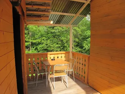 a wooden porch with a table and chairs on a deck at Apartment Zalokar in Bohinj