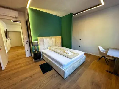a bedroom with a bed and a green wall at Eipprova deluxe apartment in Rove