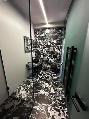 a bathroom with a black and white patterned floor at Eipprova deluxe apartment in Rove