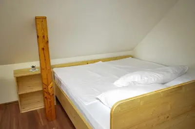 a bed in a room with a wooden bed frame at Koča v Lozah in Gornji Grad
