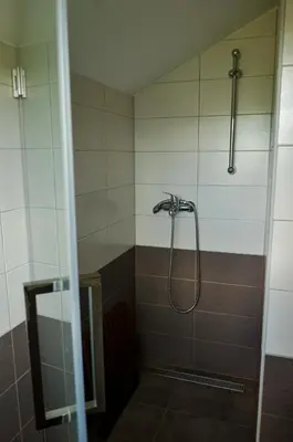 a shower with a shower head in a bathroom at Koča v Lozah in Gornji Grad