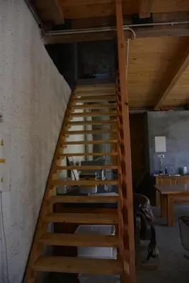a wooden staircase in a room with wooden ceilings at Turistična kmetija Pod kostanji - FarmStay Pod kostanji in Motnik