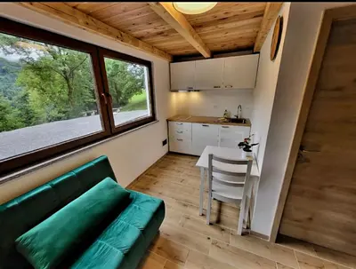 a living room with a green couch and a table at Bungalov Čuk in Most na Soči