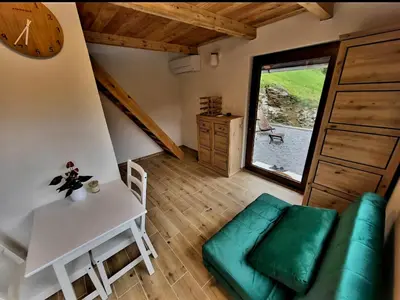 a living room with a couch and a table at Bungalov Čuk in Most na Soči