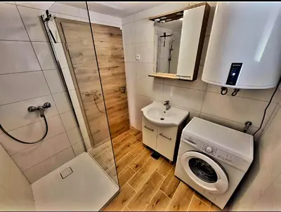 a small bathroom with a washing machine and a sink at Bungalov Čuk in Most na Soči