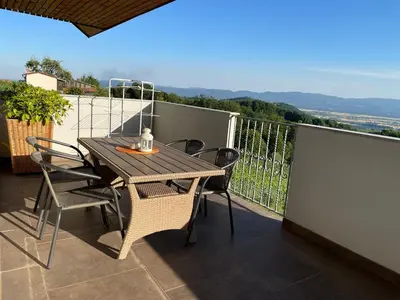 a wooden table and chairs on a balcony at Apartment9B with amazing view in Krško