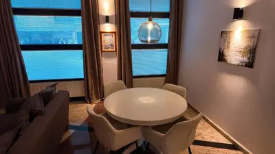 a white table and chairs in a room with windows at Luxury Apartment Simba C in Smarjeske Toplice
