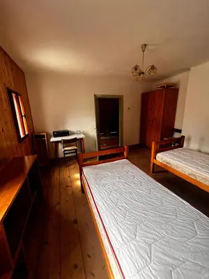 a bedroom with two beds and a desk in it at Apartma Pr'Csrlu