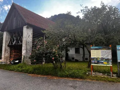 a building with a tree and a sign in front of it at Apartma Pr'Csrlu
