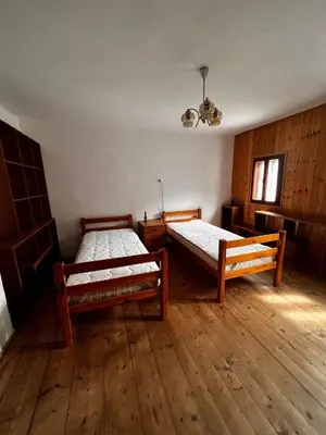 two beds in a room with wooden floors at Apartma Pr'Csrlu