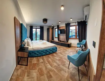 a bedroom with a large bed and a blue chair at Alpine House Mina - Rooms & Apartments in Bled