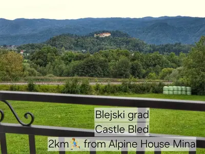 a sign sitting on a bench looking at a mountain at Alpine House Mina - Rooms & Apartments in Bled