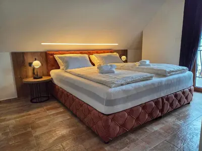 a bedroom with a large bed with two pillows at Alpine House Mina - Rooms & Apartments in Bled