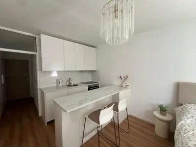 a kitchen with white cabinets and a white counter top at Designer City Oasis with Garden in Ljubljana