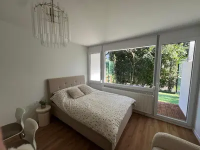 a bedroom with a bed and a large window at Designer City Oasis with Garden in Ljubljana