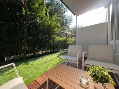 a patio with two chairs and a wooden table at Designer City Oasis with Garden in Ljubljana