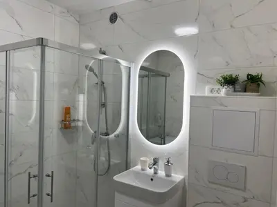 a white bathroom with a shower and a sink at Designer City Oasis with Garden in Ljubljana