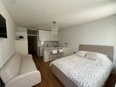 a bedroom with a bed and a couch and a kitchen at Designer City Oasis with Garden in Ljubljana