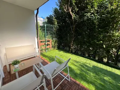 a patio with chairs and a table and a lawn at Designer City Oasis with Garden in Ljubljana