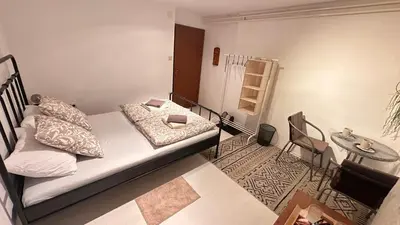 a bedroom with a bed and a table and a chair at Room under Velika planina in Stahovica