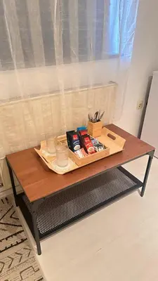 a coffee table with books on it in front of a window at Room under Velika planina in Stahovica
