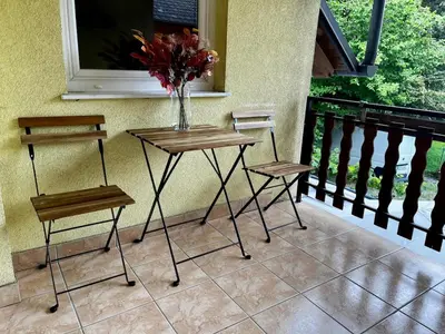 a table and two chairs and a vase of flowers on a balcony at Nature and City Access - Perfect Base in Ljubljana in Ljubljana