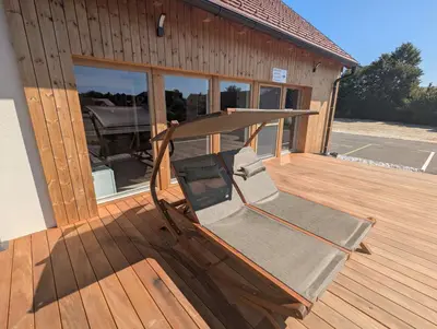 a chair sitting on a deck next to a building at Štuhecova domačija