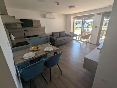 a kitchen and a living room with a table and chairs at Štuhecova domačija