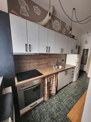 a kitchen with white cabinets and a sink at Studio AK in Žalec