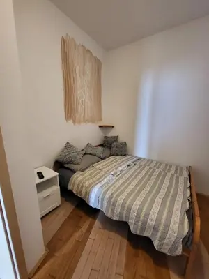 a bedroom with a bed and a wooden floor at Studio AK in Žalec