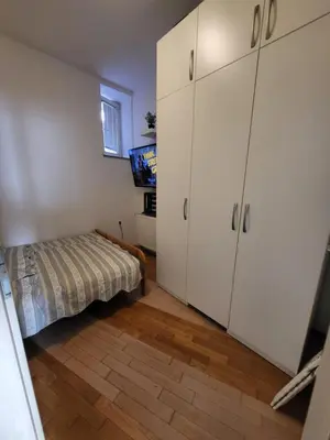 a bedroom with a bed and white cabinets at Studio AK in Žalec