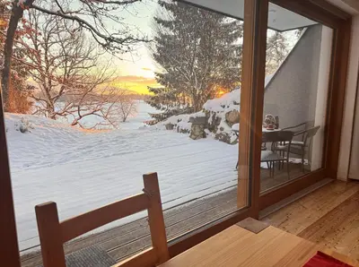 a room with a view of a snow covered yard at Bled Forest Apartment in Bled