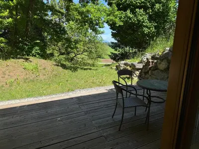 a patio with a table and chairs on a deck at Bled Forest Apartment in Bled