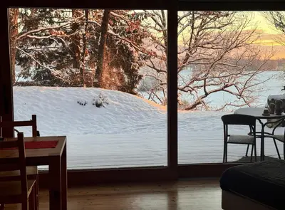 a view of a snow covered yard through a window at Bled Forest Apartment in Bled