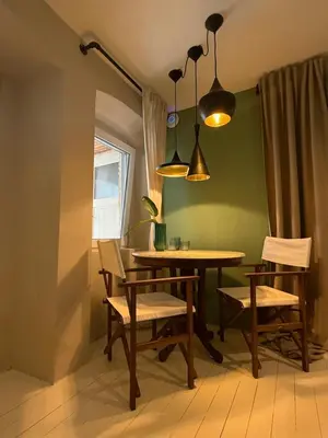 a dining room with a table and chairs and lights at Vida's homes in Ljubljana
