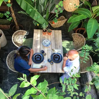 two people sitting at a table in a garden at Vida's homes in Ljubljana