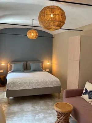 a bedroom with a bed and two lamps and a couch at Vida's homes in Ljubljana