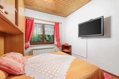 a bedroom with a bed and a flat screen tv at Ranč Katja in Abdul in Materija