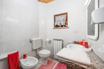 a white bathroom with a toilet and a sink at Ranč Katja in Abdul in Materija