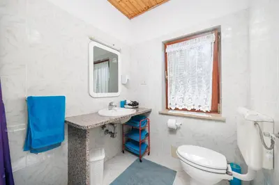 a white bathroom with a toilet and a sink at Ranč Katja in Abdul in Materija