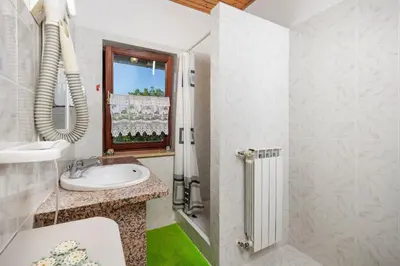 a white bathroom with a sink and a window at Ranč Katja in Abdul in Materija