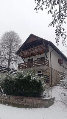a house with snow on the ground in front of it at Retreat House River Krka - Hiša oddiha reka Krka in Krka