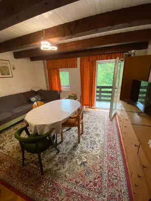 a living room with a table and a couch at Retreat House River Krka - Hiša oddiha reka Krka in Krka