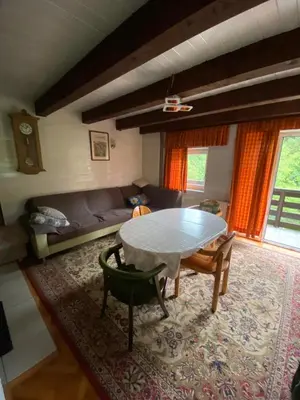 a living room with a table and a couch at Retreat House River Krka - Hiša oddiha reka Krka in Krka