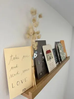 a shelf with books and a vase with flowers at Cukr in Ljubljana