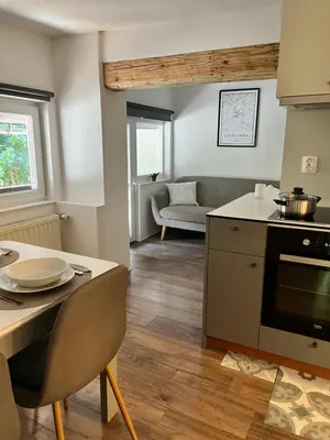 a kitchen and living room with a table and a couch at Cukr in Ljubljana