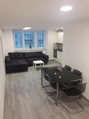 a living room with a black couch and a table at Apartment Emona Ljubljana in Ljubljana